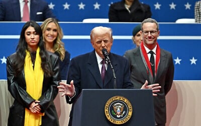 US President Donald Trump speaks alongside former hostage Noa Argamani (left) and hostage envoy Adam Boehler (right) during the inaugural parade inside Capital One Arena, in Washington, DC, on January 20, 2025. (Angela Weiss / AFP)