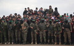 Illustrative: Palestinian Hamas fighters and people gather in Nuseirat in the central Gaza Strip, as preparations take place for the release of three Israeli hostages as part of the seventh hostage-prisoner swap on February 22, 2025. (Bashar Taleb / AFP)