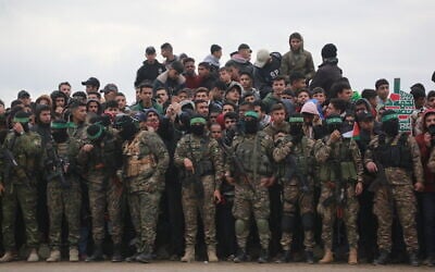 Illustrative: Palestinian Hamas fighters and people gather in Nuseirat in the central Gaza Strip, as preparations take place for the release of three Israeli hostages as part of the seventh hostage-prisoner swap on February 22, 2025. (Bashar Taleb / AFP)