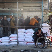 Palestinians queue to receive food aid from an UNRWA distribution center at the Nuseirat refugee camp in the central Gaza Strip on March 3, 2025. (Eyad BABA / AFP)