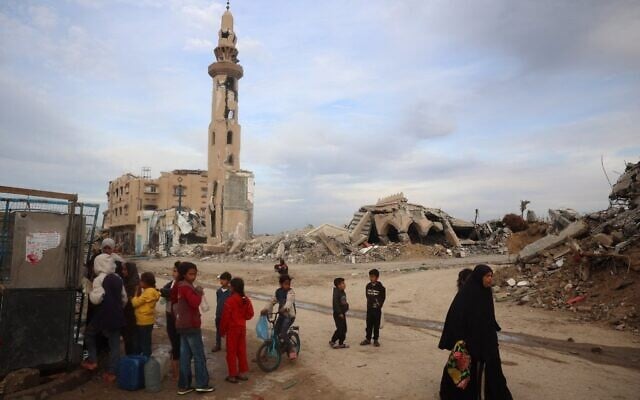Palestinians refill on water next to a destroyed mosque at the Nuseirat refugee camp in the central Gaza Strip on March 3, 2025. (Eyad BABA / AFP) Palestinians refill on water next to a destroyed mosque at the Nuseirat refugee camp in the central Gaza Strip on March 3, 2025. (Eyad BABA / AFP)