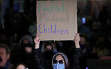 An anti-Israel protester holds up a sign outside the campus of Columbia University in New York City on March 4, 2025, to protest a speech by former prime minister Naftali Bennett (CHARLY TRIBALLEAU / AFP)