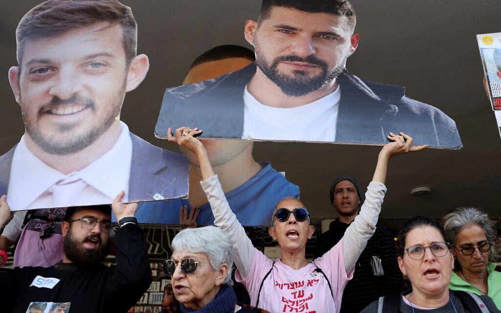 Demonstrators raise cutout portraits of Israeli hostages during a protest calling for the implementation of the second phase and the completion of the agreement for the release of all hostages held captive in Gaza since the October 7, 2023  in Tel Aviv on March 6, 2025.(Photo by Jack GUEZ / AFP)