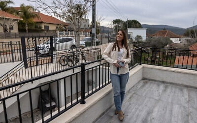 Carmela Keren Yakuti poses for a picture outside her house as residents return to their homes in Dovev, a moshav or cooperative agricultural community in northern Israel close to the border with Lebanon on March 3, 2025 (Menahem KAHANA / AFP)