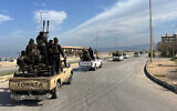 This handout picture released by the official Syrian Arab News Agency (SANA) shows members of the Syrian security forces entering the western city of Baniyas in Syria's coastal Tartous province to reinforce government troops in clashes with militants loyal to deposed ruler Bashar al-Assad, on March 7, 2025. (Photo by SANA / AFP)