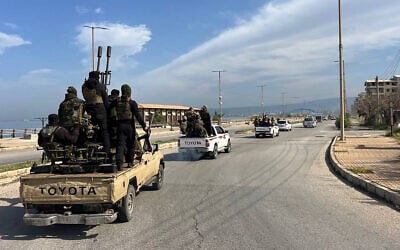This handout picture released by the official Syrian Arab News Agency (SANA) shows members of the Syrian security forces entering the western city of Baniyas in Syria's coastal Tartous province to reinforce government troops in clashes with militants loyal to deposed ruler Bashar al-Assad, on March 7, 2025. (Photo by SANA / AFP)