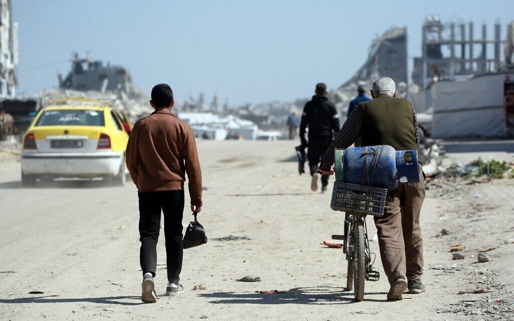 A Palestinian man ferries a gas cylinder on his bicycle at a displacement camp west of Jabalia city in the northern Gaza Strip on March 11, 2025. (Bashar TALEB / AFP)