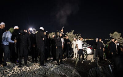 A man fires a weapon in the air ahead of the arrival of Syrian Druze clerics at the tomb of Nabi Shuaib in northern Israel on March 14, 2025. There is no suggestion the man depicted caused the injury of a woman (John Wessels / AFP)