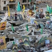 Pictures of Hassan Nasrallah, the slain former leader of Lebanese Shiite terror group Hezbollah, and other killed fighters are displayed amid the rubble of destroyed buildings as people prepare a mass fast-breaking iftar meal in Lebanon's southern village of Khiam, near the border with Israel on March 15, 2025. (Photo by Rabih DAHER / AFP)