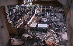 Palestinians gather for a mass fast-breaking Iftar meal amid the rubble of destroyed buildings in Beit Lahiya in the northern Gaza Strip on March 15, 2025, during the Muslim holy fasting month of Ramadan. (Omar AL-Qattaa/AFP)