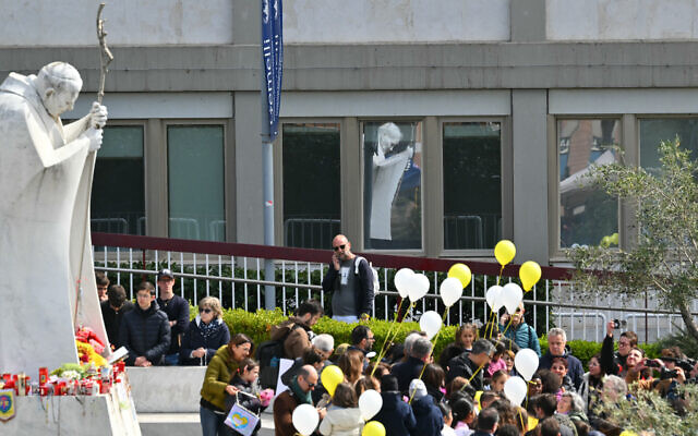 Children holding white and yellow balloons gather by the statue of John Paul II outside the Gemelli University Hospital where Pope Francis is hospitalised, in Rome on March 16, 2025. (Photo by Andreas SOLARO / AFP) Children holding white and yellow balloons gather by the statue of John Paul II outside the Gemelli University Hospital where Pope Francis is hospitalised, in Rome on March 16, 2025. (Photo by Andreas SOLARO / AFP)