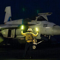 This handout photo released by the US Defence Visual Information Distribution Service (DVIDS) shows a US Navy officer signalling for a F/A-18 Super Hornet attack fighter jet preparing for take off from the USS Nimitz-class USS Harry S. Truman aircraft carrier at sea on March 16, 2025. (Logan NYSTRAND / DVIDS / AFP)