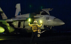 This handout photo released by the US Defence Visual Information Distribution Service (DVIDS) shows a US Navy officer signalling for a F/A-18 Super Hornet attack fighter jet preparing for take off from the USS Nimitz-class USS Harry S. Truman aircraft carrier at sea on March 16, 2025. (Logan NYSTRAND / DVIDS / AFP)