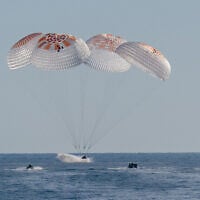 This handout picture provided by NASA shows support teams work around a SpaceX Dragon spacecraft shortly after it landed with NASA astronauts Nick Hague, Suni Williams, Butch Wilmore, and Roscosmos cosmonaut Aleksandr Gorbunov aboard in the water off the coast of Tallahassee, Florida, on March 18, 2025. (Keegan Barber / NASA / AFP)