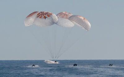 This handout picture provided by NASA shows support teams work around a SpaceX Dragon spacecraft shortly after it landed with NASA astronauts Nick Hague, Suni Williams, Butch Wilmore, and Roscosmos cosmonaut Aleksandr Gorbunov aboard in the water off the coast of Tallahassee, Florida, on March 18, 2025. (Keegan Barber / NASA / AFP)
