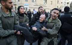 National Guard officers, distinguishable from standard Border Police by patches with the force's insignia on their uniform sleeves, carry away a protester during a demonstration against Prime Minister Benjamin Netanyahu and calling for an end to the war in Gaza on March 19, 2025. (Menahem Kahana/AFP)