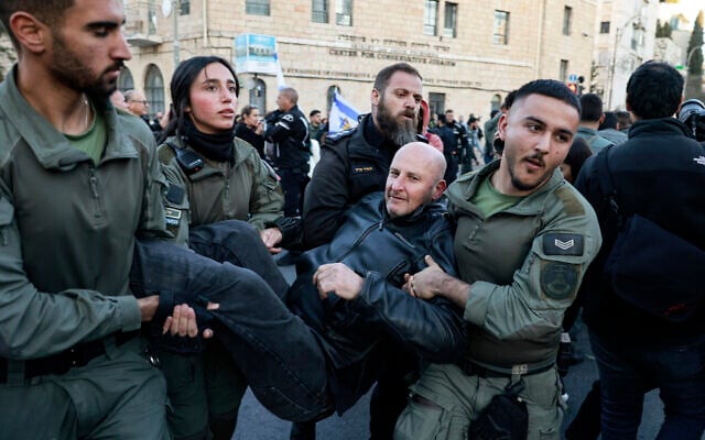 National Guard officers, distinguishable from standard Border Police by patches with the force's insignia on their uniform sleeves, carry away a protester during a demonstration against Prime Minister Benjamin Netanyahu and calling for an end to the war in Gaza on March 19, 2025. (Menahem Kahana/AFP) National Guard officers, distinguishable from standard Border Police by patches with the force's insignia on their uniform sleeves, carry away a protester during a demonstration against Prime Minister Benjamin Netanyahu and calling for an end to the war in Gaza on March 19, 2025. (Menahem Kahana/AFP)