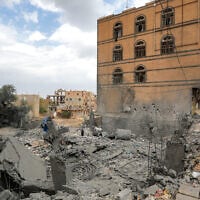 People gather by the rubble of a collapsed building at the site of a reported US air strike on Yemen's Houthi-held capital Sanaa on March 24, 2025 (Mohammed Huwais/AFP)