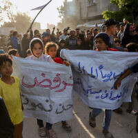 Children carry signs reading in Arabic: 'We refuse to die' during an anti-Hamas rally calling for an end to the war, in Beit Lahia, in the northern Gaza Strip, on March 25, 2025. (AFP)