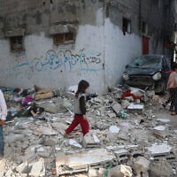 Palestinian children stand on rubble after an earlier Israeli strike hit an apartment in the Bureij refugee camp in the central Gaza Strip on March 26, 2025.  (Photo by Eyad BABA / AFP)
