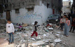 Palestinian children stand on rubble after an earlier Israeli strike hit an apartment in the Bureij refugee camp in the central Gaza Strip on March 26, 2025.  (Photo by Eyad BABA / AFP)