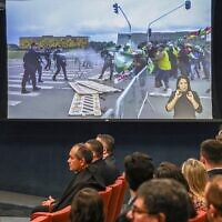 Handout picture released by Brazilian Supreme Court shows a TV projecting images of a protest in Brasilia on January 2023, during a session to decide if former president Jair Bolsonaro will face trial in Brasilia on March 26, 2025. (Antonio AUGUSTO / Brazilian Supreme Court / AFP)
