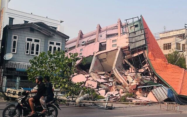 People drive on a motorbike past a collapsed building in Mandalay on March 28, 2025, after an earthquake in central Myanmar (AFP) People drive on a motorbike past a collapsed building in Mandalay on March 28, 2025, after an earthquake in central Myanmar (AFP)