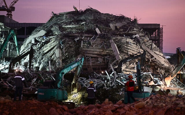 Heavy construction equipment is used to find people trapped in the rubble at the site of an under-construction building collapse as the sun sets in Bangkok on March 29, 2025, a day after an earthquake struck central Myanmar and Thailand. (MANAN VATSYAYANA / AFP)