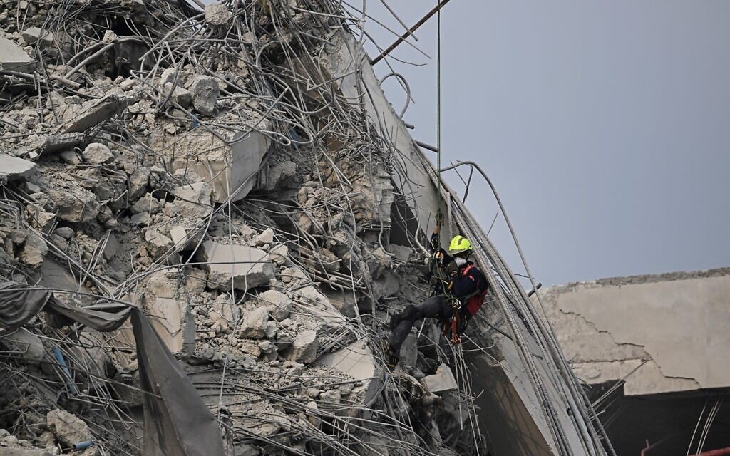 A rescue worker descends towards the body of a missing person at the site of an under-construction building collapse in Bangkok on March 30, 2025 (Lillian SUWANRUMPHA / AFP)