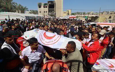 Members of the Palestine Red Crescent and other emergency services carry bodies of fellow rescuers killed a week earlier by Israeli forces, during a funeral procession at Nasser hospital in Khan Younis in the southern Gaza Strip on March 31, 2025. (Eyad BABA / AFP)