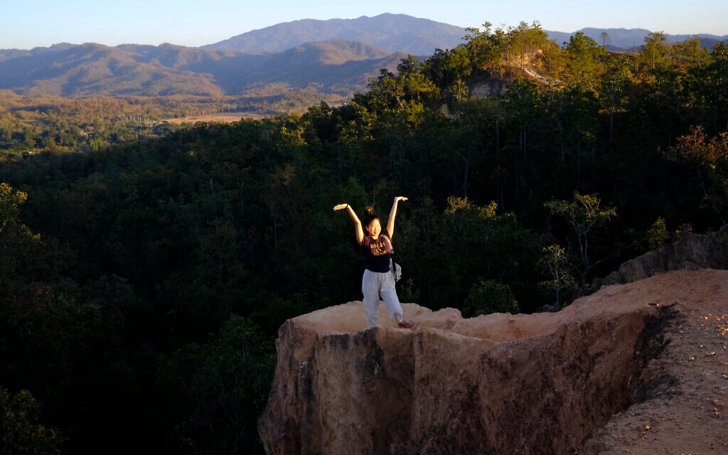 Illustrative: A tourist poses on the edge of a cliff in Pai Canyon, Pai, northern Thailand, January 3, 2022. (AP Photo/Wally Santana)
