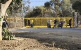 Palestinian terrorists are seen at an entrance to Kibbutz Nir Oz, during the Hamas-led onslaught on October 7, 2023. (AP/Hassan Eslaiah)