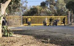 Palestinian terrorists are seen at an entrance to Kibbutz Nir Oz, during the Hamas-led onslaught on October 7, 2023. (AP/Hassan Eslaiah)