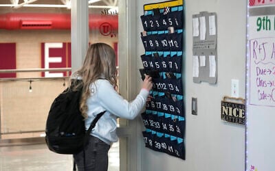Illustrative: A US ninth grader places her cellphone in to a phone holder as she enters class at Delta High School, February 23, 2024, in Delta, Utah. (AP Photo/Rick Bowmer)