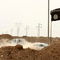 FILE - Islamic State militants pass a checkpoint bearing the group's trademark black flag in the village of Maryam Begg in Kirkuk, 180 miles north of Baghdad, Iraq, Sept. 29, 2014. (AP Photo/Hadi Mizban, File)