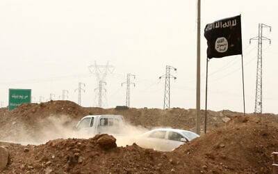 FILE - Islamic State militants pass a checkpoint bearing the group's trademark black flag in the village of Maryam Begg in Kirkuk, 180 miles north of Baghdad, Iraq, Sept. 29, 2014. (AP Photo/Hadi Mizban, File)