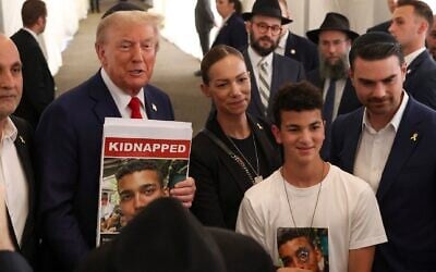 Former US president Donald Trump poses for photos with family members of Edan Alexander, a hostage held by Hamas, after visiting the gravesite of Rabbi Menachem Mendel Schneerson, October 7, 2024, in New York. (AP Photo/Yuki Iwamura)