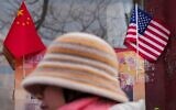 A woman walks by the Chinese and US national flags on display outside a souvenir shop in Beijing on January 31, 2025. (AP Photo/Andy Wong)