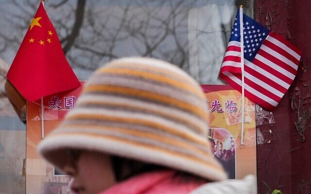 A woman walks by the Chinese and US national flags on display outside a souvenir shop in Beijing on January 31, 2025. (AP Photo/Andy Wong) A woman walks by the Chinese and US national flags on display outside a souvenir shop in Beijing on January 31, 2025. (AP Photo/Andy Wong)