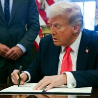 US President Donald Trump signs an executive order in the Oval Office at the White House in Washington, Tuesday, Feb. 25, 2025. (Pool via AP)