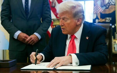 US President Donald Trump signs an executive order in the Oval Office at the White House in Washington, Feb. 25, 2025. (Pool via AP)