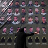 A woman reacts next to pictures of Hezbollah fighters at a mass funeral in southern Lebanon on Feb. 28, 2025. (AP/Hassan Ammar)