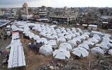 A sprawling tent camp for displaced Palestinians sits adjacent to destroyed homes and buildings in Gaza City, Gaza Strip, March 1, 2025 during the Muslim holy month of Ramadan. (AP Photo/Abdel Kareem Hana)