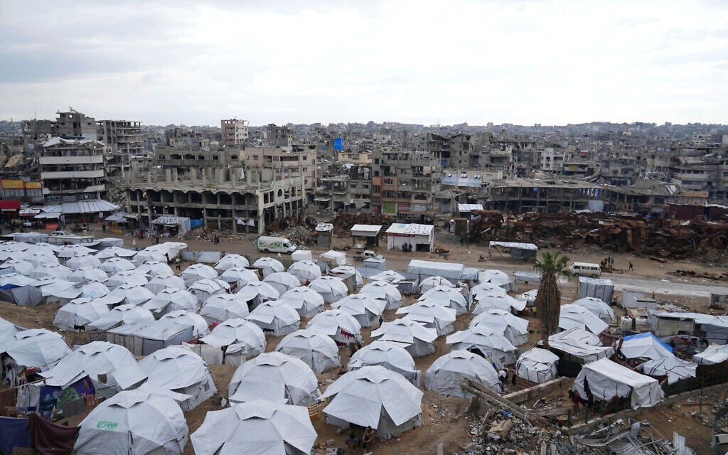 A sprawling tent camp for displaced Palestinians sits adjacent to destroyed homes and buildings in Gaza City, Gaza Strip, Saturday, March 1, 2025 (AP Photo/Abdel Kareem Hana)