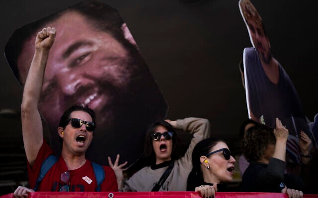 Demonstrators hold photos depicting the faces of Israeli hostages who are being held in the Gaza Strip, during a protest demanding their release from Hamas captivity, in Tel Aviv, Israel, Thursday, March 6, 2025. (AP Photo/Oded Balilty)