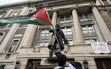 A student protester parades a Palestinian flag outside the entrance to Hamilton Hall on the campus of Columbia University, in New York, April 30, 2024. (Mary Altaffer/AP)