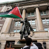 A student protester parades a Palestinian flag outside the entrance to Hamilton Hall on the campus of Columbia University, in New York, April 30, 2024. (Mary Altaffer/AP)