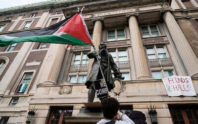 A student protester parades a Palestinian flag outside the entrance to Hamilton Hall on the campus of Columbia University, in New York, April 30, 2024. (Mary Altaffer/AP)