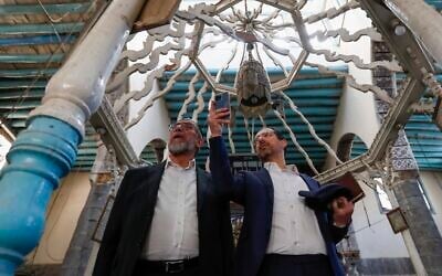 Rabbi Yusuf Hamra, left, and his son Henry take pictures as they visit the Al-Raqi synagogue in the old city of Damascus Feb. 18, 2025. (AP Photo/Omar Sanadiki, File)
