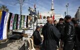Druze men gather by a newsstand selling flags of Syria and the Druze community at Al Karama Square in city of Sweida, Syria, March 4, 2025.(Omar Sanadiki/AP)